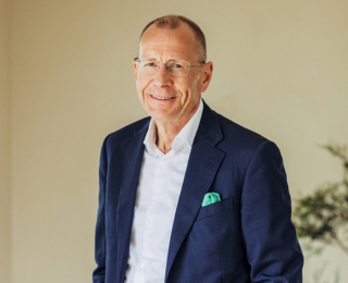 Man with glasses and in a suit smiling