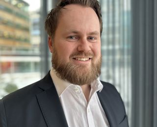 Man i suit smiling to the camera